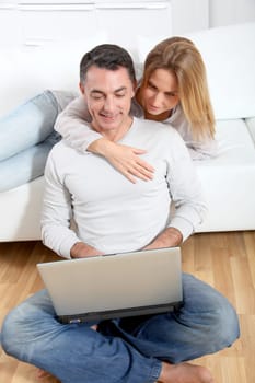 Happy couple surfing on internet at home