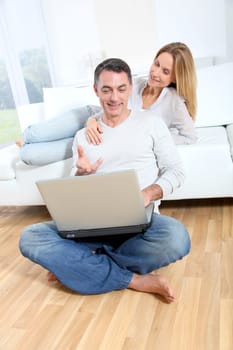 Happy couple surfing on internet at home
