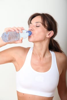 Closeup of woman drinking water after exercising