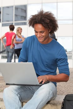 Student at college campus with laptop computer