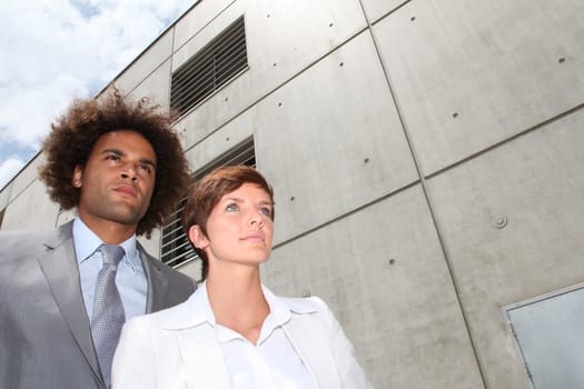 Closeup of businesspeople in front of concrete wall