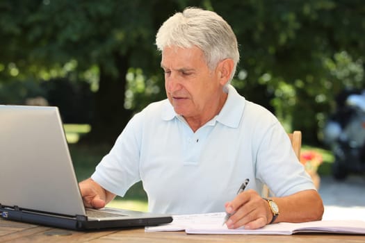 Closeup of senior man with laptop computer at home
