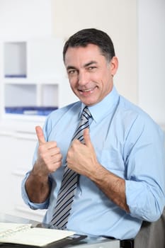 Man in the office showing positivity
