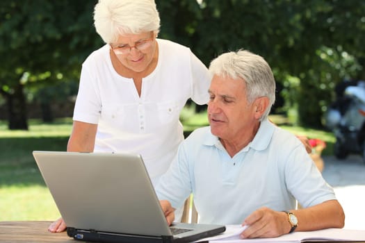 Senior couple using laptop computer at home