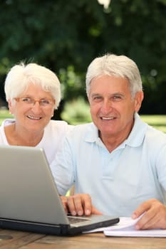 Senior couple at home surfing on internet