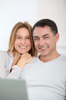 Happy couple surfing on internet at home