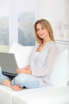 Beautiful blond woman surfing on internet at home