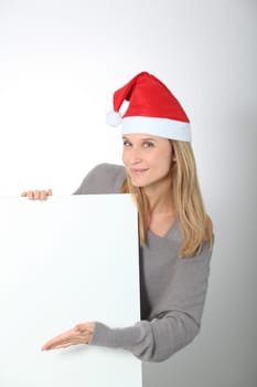 Blond woman with Santa hat showing white board