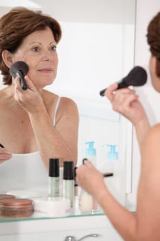 Closeup of senior woman putting makeup on