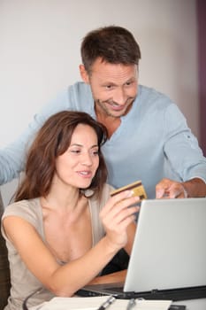 Couple at home shopping on internet