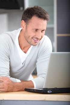Man with laptop computer in kitchen