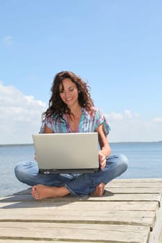 Woman using laptop computer on a pontoon
