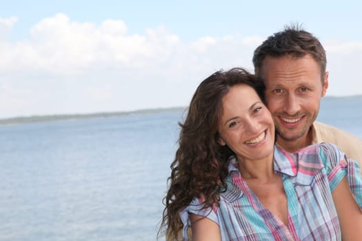 Closeup of loving couple standing on a pontoon by a lake