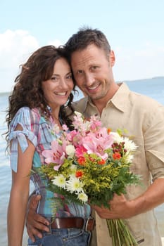 Man surprising woman with bunch of flowers
