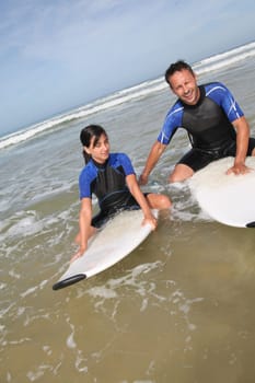 Father and daughter surfing in the ocean