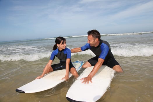 Father and daughter surfing in the ocean