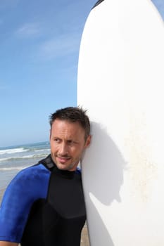 Man standing in water with surfboard