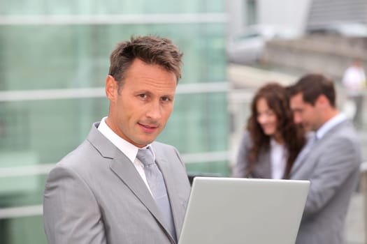 Businessman standing in front of offices outside