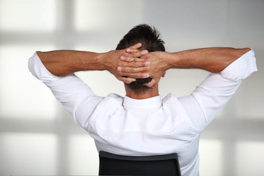 Businessman stretching arms in the office