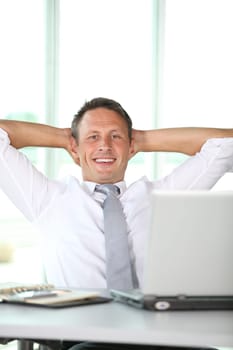 Businessman stretching arms in the office