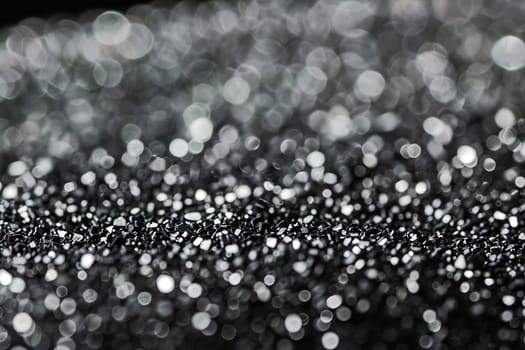 Close-up of silver glitter bokeh with sparkling highlights and abstract texture.