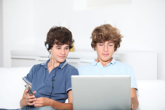Teenagers with music player and computer at home
