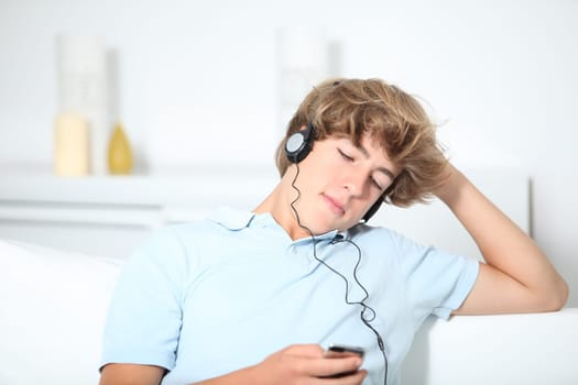 Teenager listeing to music in sofa