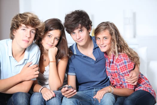 Group of teenagers at home with music player