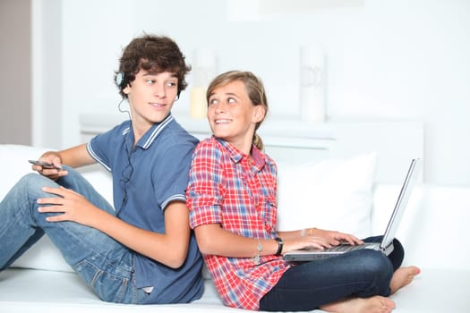 Teenagers with music player and computer at home
