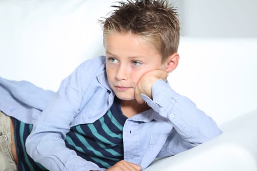 Young boy laying on a sofa at home