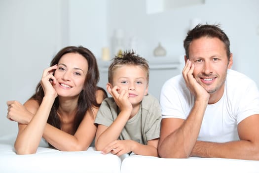 Closeup of parents and child relaxing at home on sofa
