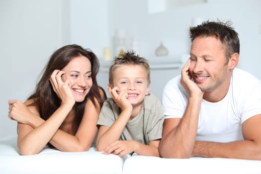 Closeup of parents and child relaxing at home on sofa
