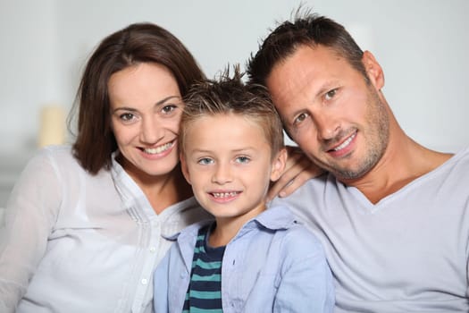 Closeup of parents and child relaxing at home on sofa