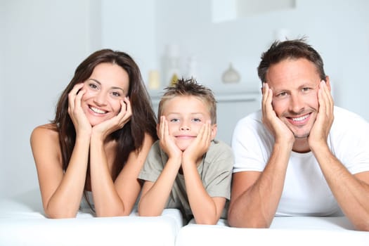 Closeup of parents and child relaxing at home on sofa