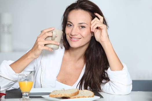 Beautiful woman having breakfast at home