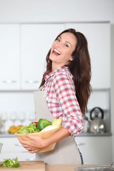 Beautiful woman stading in kitchen with apron
