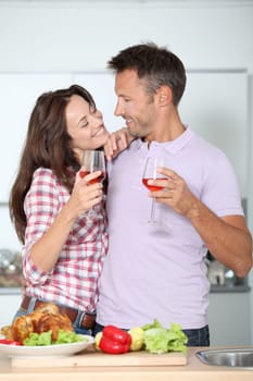 Couple drinking wine while fixing dinner