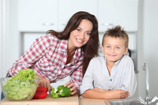 Mother cooking with son in kitchen