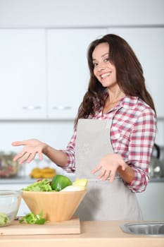 Beautiful woman stading in kitchen with apron