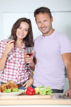 Couple drinking wine while fixing dinner