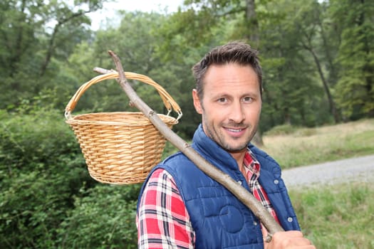 Closeup of man with basket looking for mushrooms on the ground