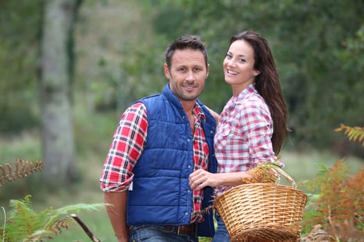 Couple in forest picking mushrooms in autumn