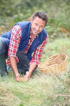 Closeup of man with basket looking for mushrooms on the ground