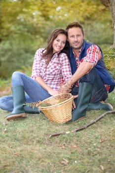 Couple in forest picking mushrooms in autumn