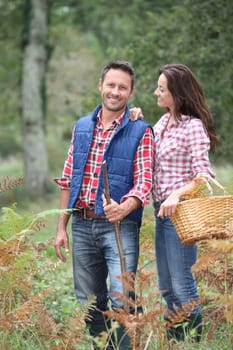 Couple in forest picking mushrooms in autumn