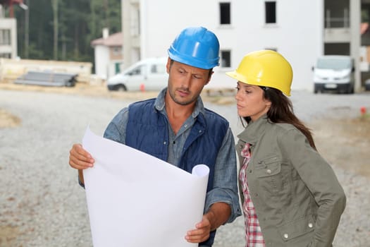 Team of architects checking plans on site