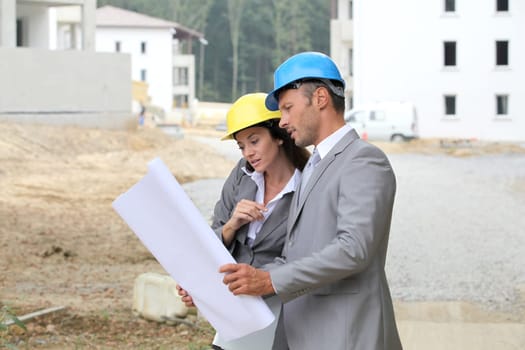 Team of architects checking plans on site