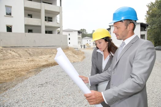 Team of architects checking plans on site