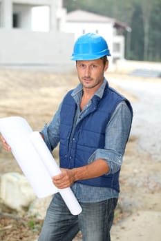 Businessman with helmet checking site under construction