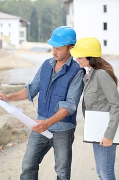 Team of architects checking plans on site